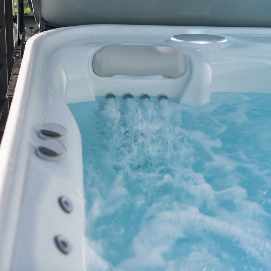 Hot tub seat with water jets actively circulating, creating bubbling water inside the spa.