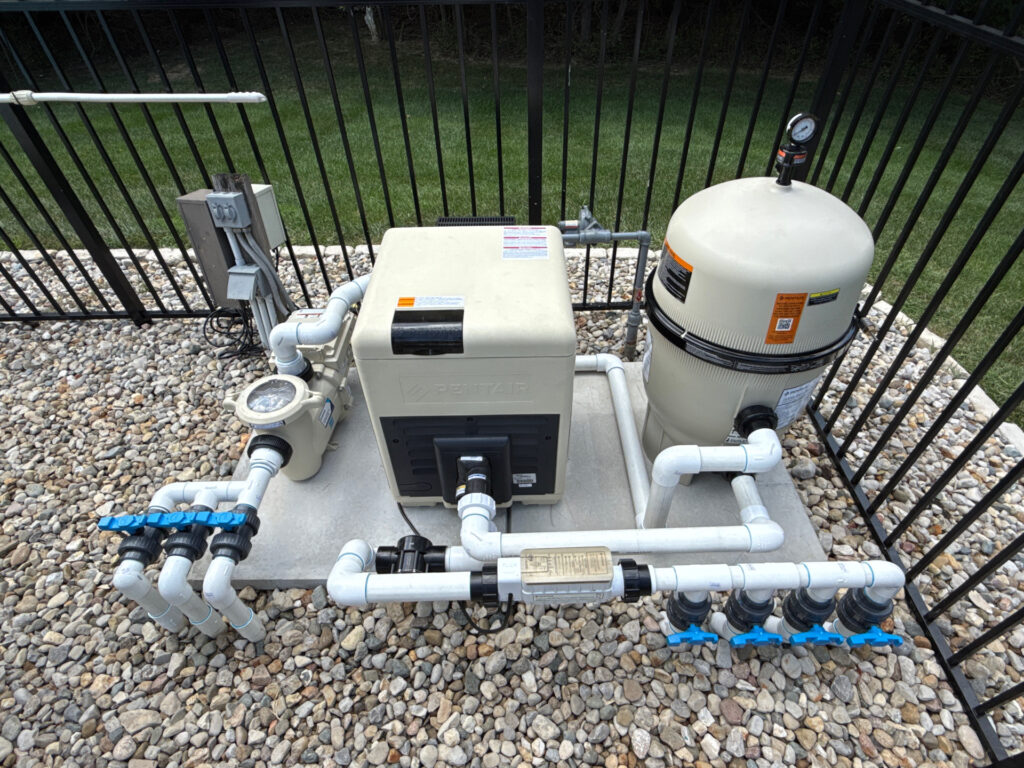 Swimming pool equipment including heater, filter, pump, and plumbing installed for efficient pool operation.